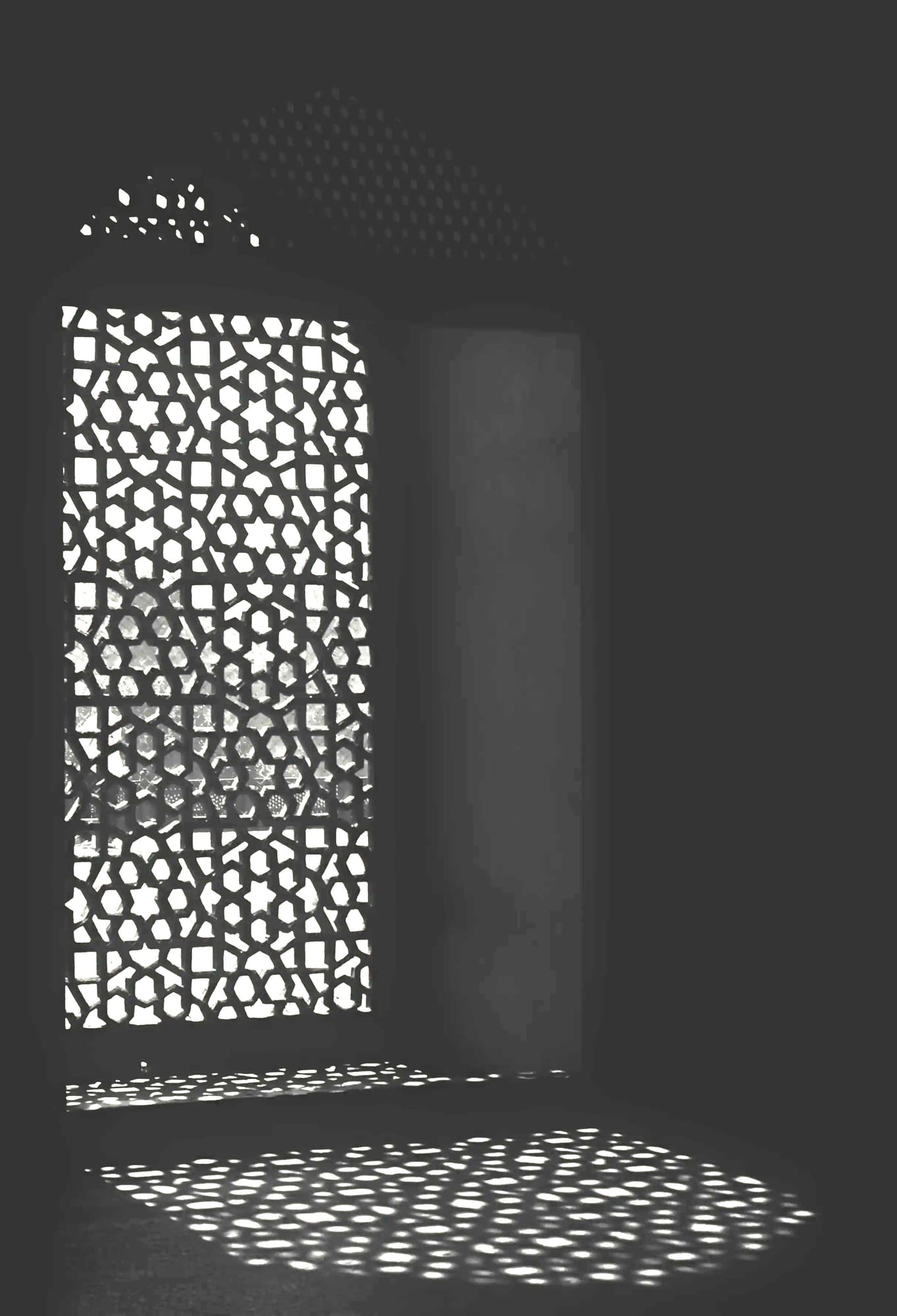 Light falling through a carved jaali lattice window